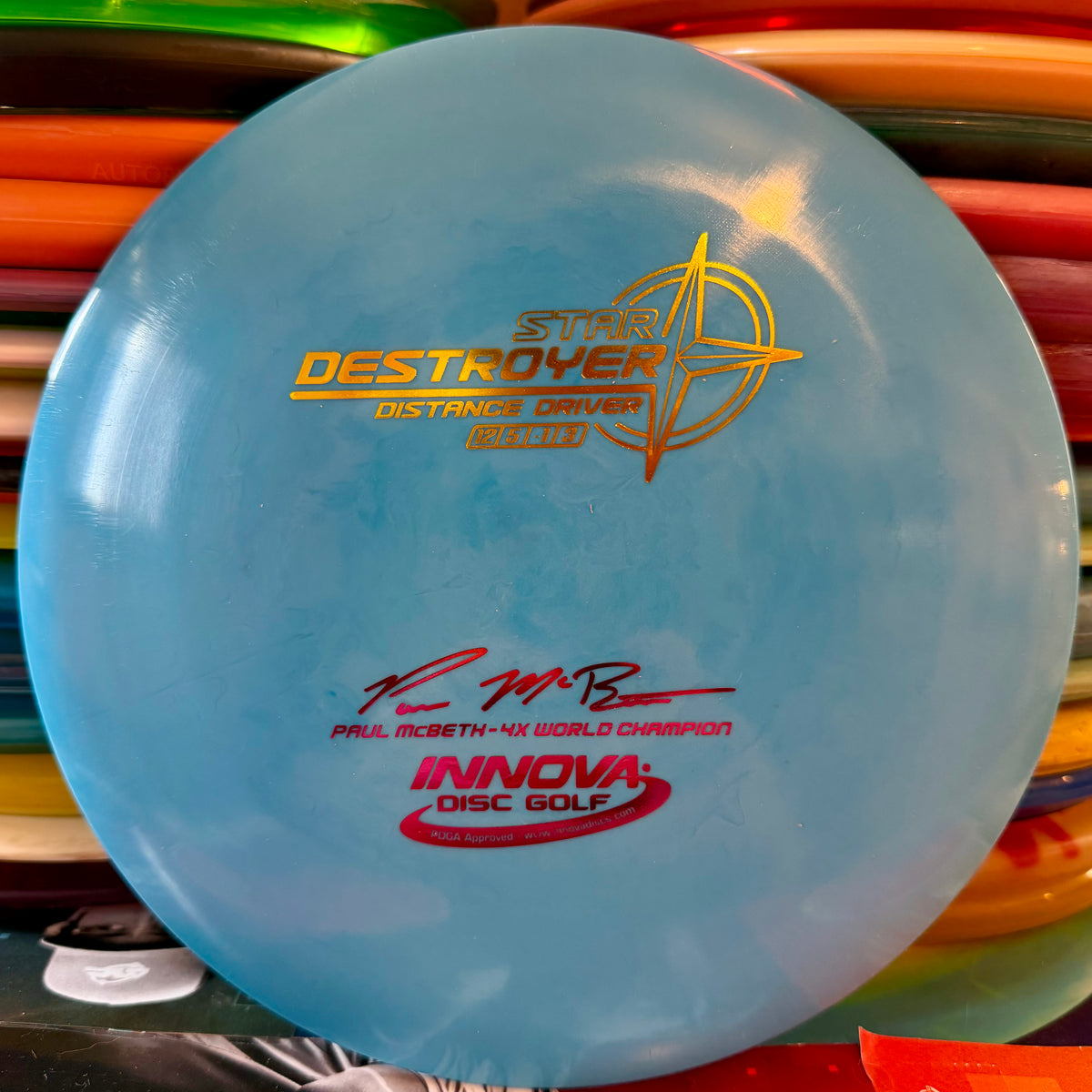 Innova Paul McBeth 4x Star Destroyer distance driver, light blue with a gold embossed Star Destroyer stamp and red Paul McBeth 4x World Champion signature, top view