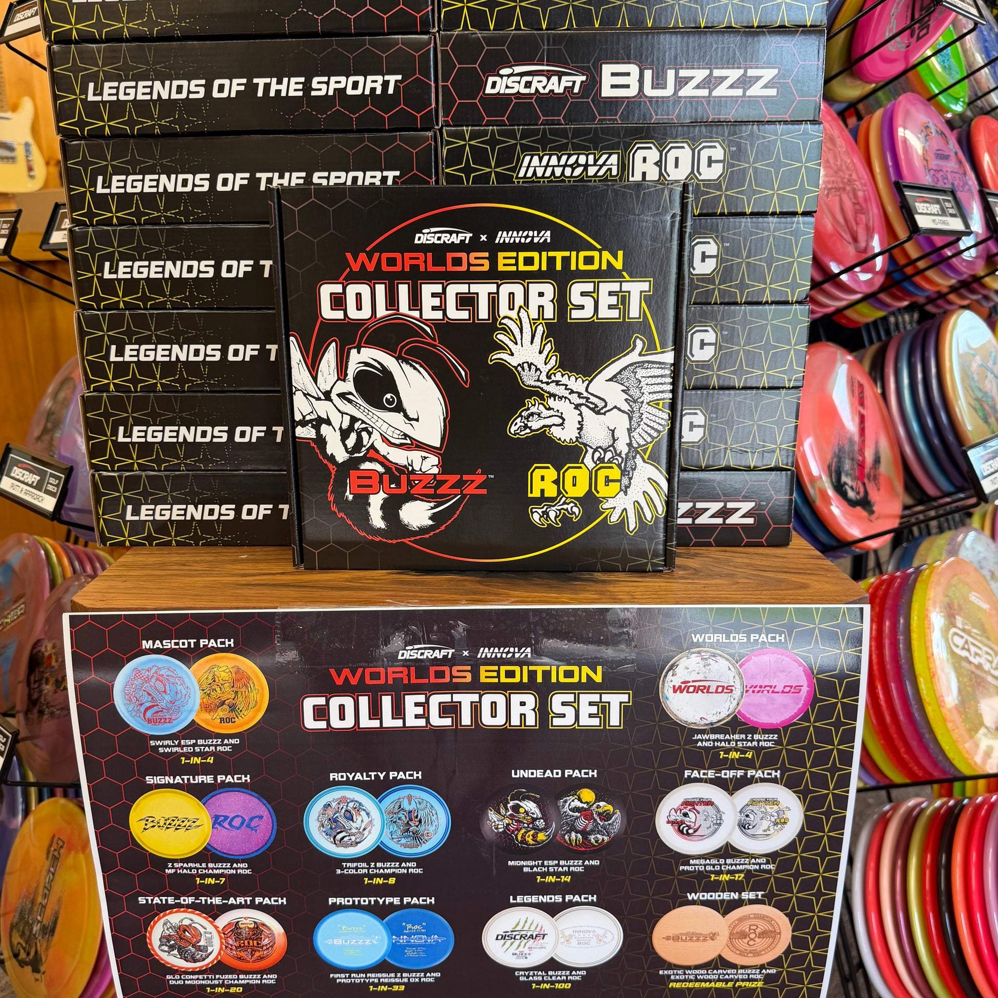 Discraft Buzzz and Inovna ROC Worlds Edition Collector Set packaging displayed on a retail shelf, with multiple black collector set boxes stacked behind and a circular set insert card below.